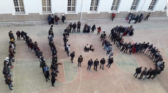 Demonstrators position themselves to spell out